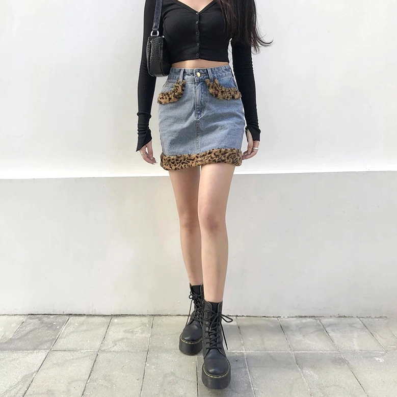 Blue wash denim mini skirt with leopard print fuzzy accent, worn model back view
