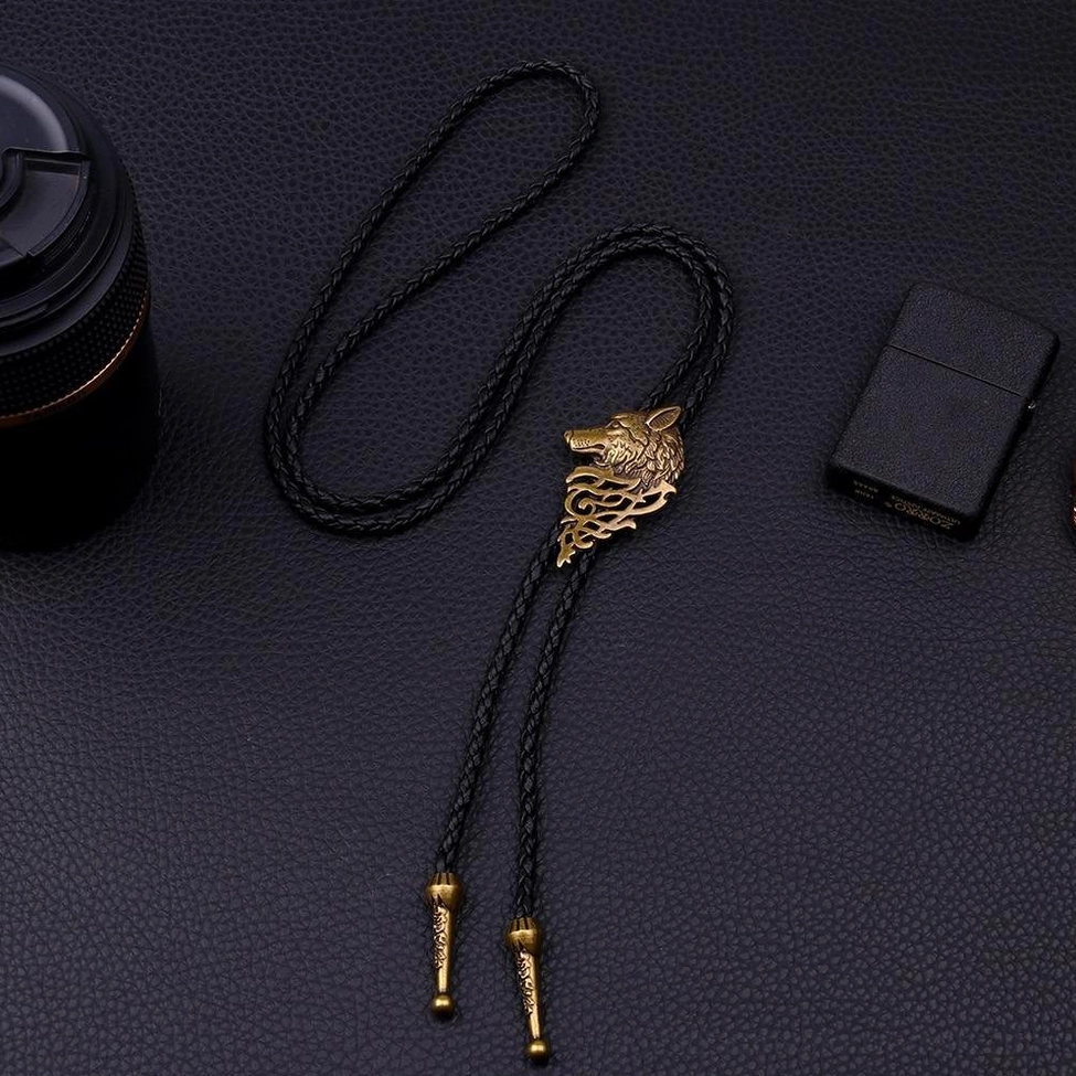 Bronze wolf head gothic choker necklace flat lay top view with black rope and metallic finishing details