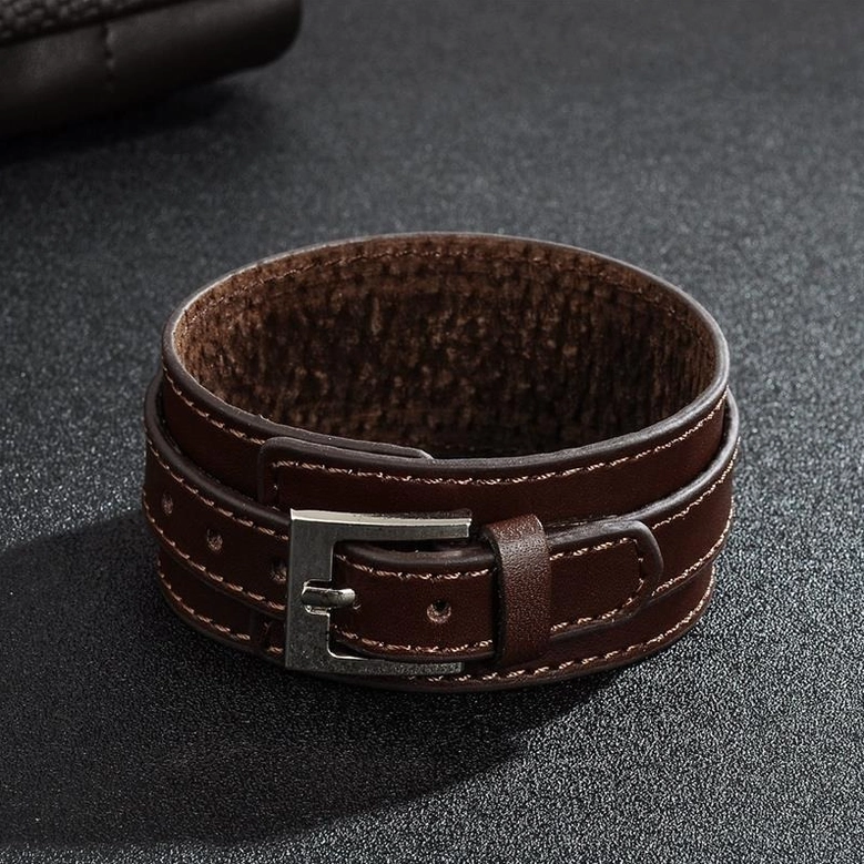 Brown double-layer gothic leather wristband with silver metal clasp on textured background, adjustable fit design