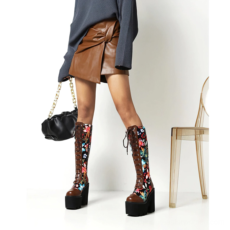 Model wearing two-tone gothic floral platform boots with brown leather accents, paired with grey top and brown leather skirt