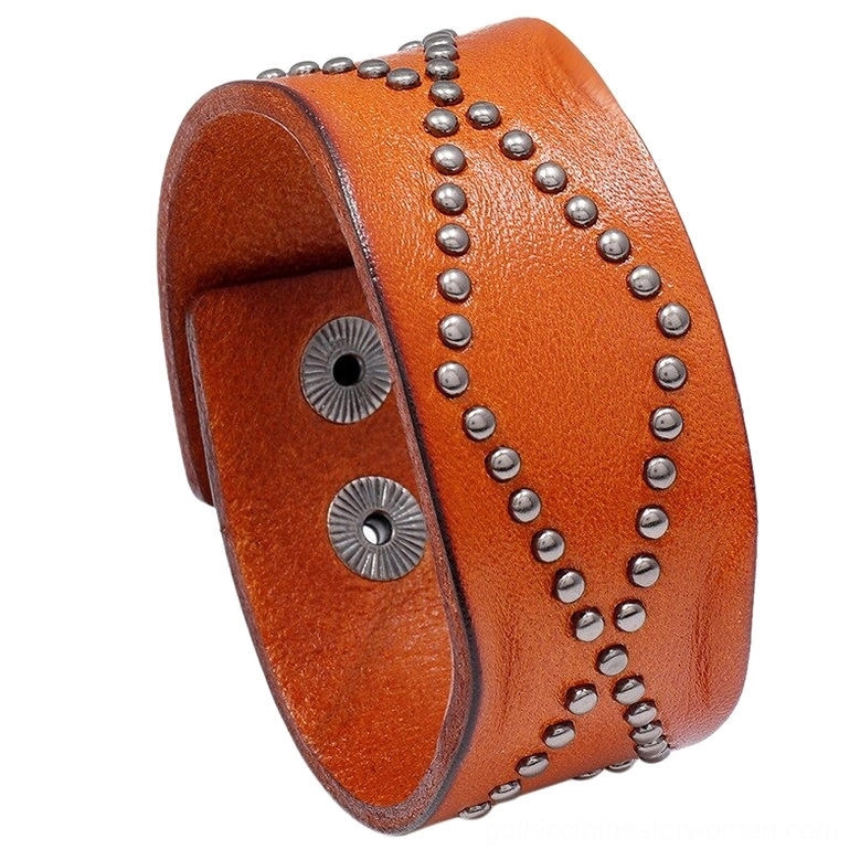 Brown leather gothic cuff bracelet with studded cross pattern and industrial rivet design, angled product photography on white background