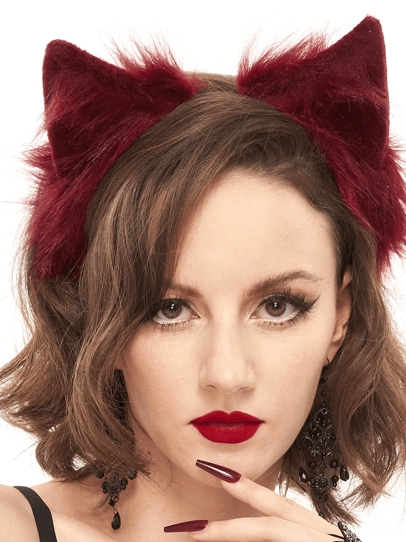 Front view of burgundy faux fur cat ears headpiece on model with short curly hair, hand pose near chin