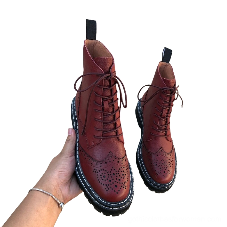 Burgundy leather gothic ankle boots in hand showing rich color, lace-up design, and platform lug sole construction
