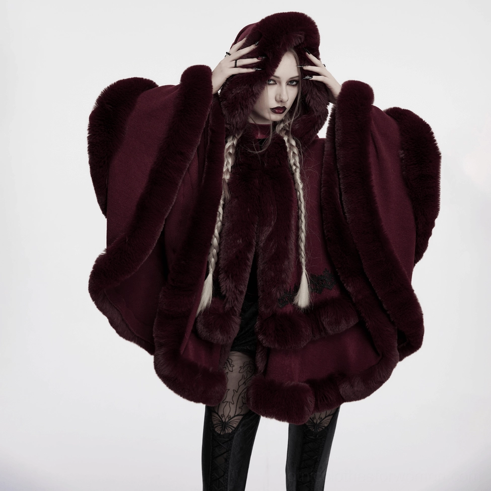 Model wearing burgundy gothic hooded cloak showcasing theatrical silhouette and alternative fashion styling