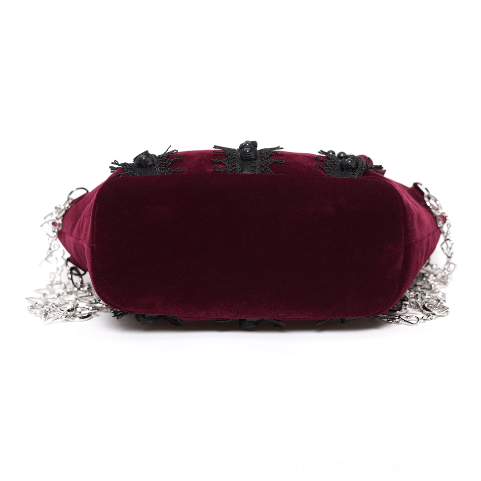 Burgundy gothic rose handbag side profile highlighting smooth velvet exterior, structured silhouette, and detachable chain strap design