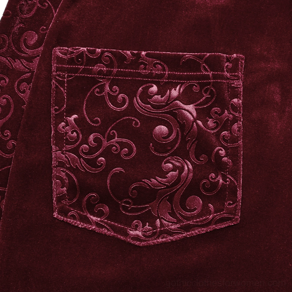 Close-up detail of embossed scroll pattern on burgundy velvet gothic pants pocket