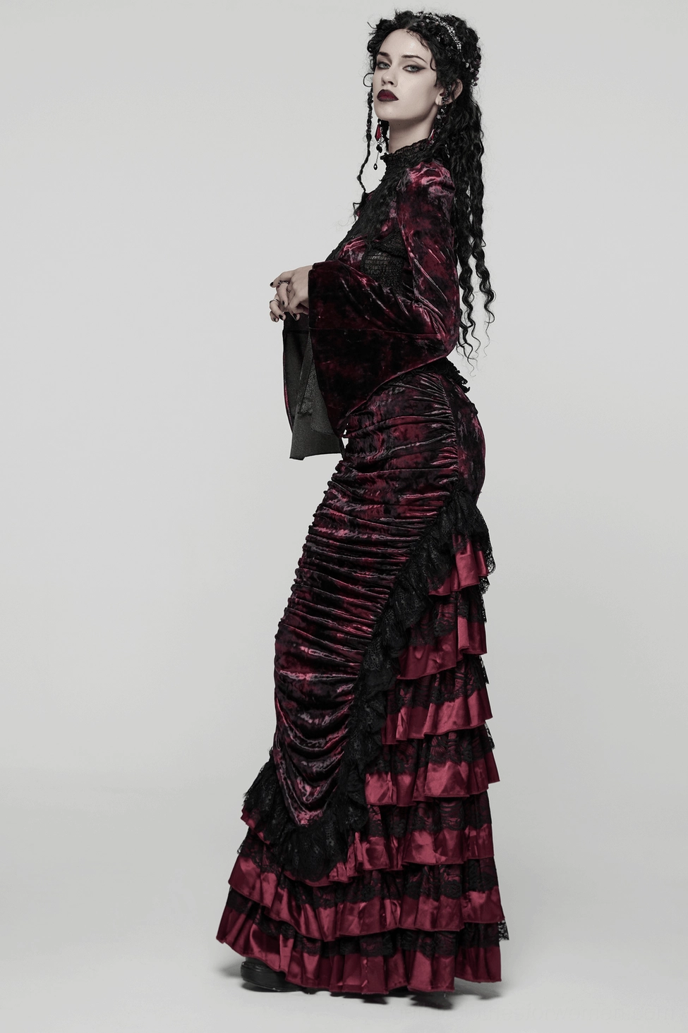 Burgundy velvet gothic skirt layered with fishnet stockings and platform boots showcasing complete alternative look