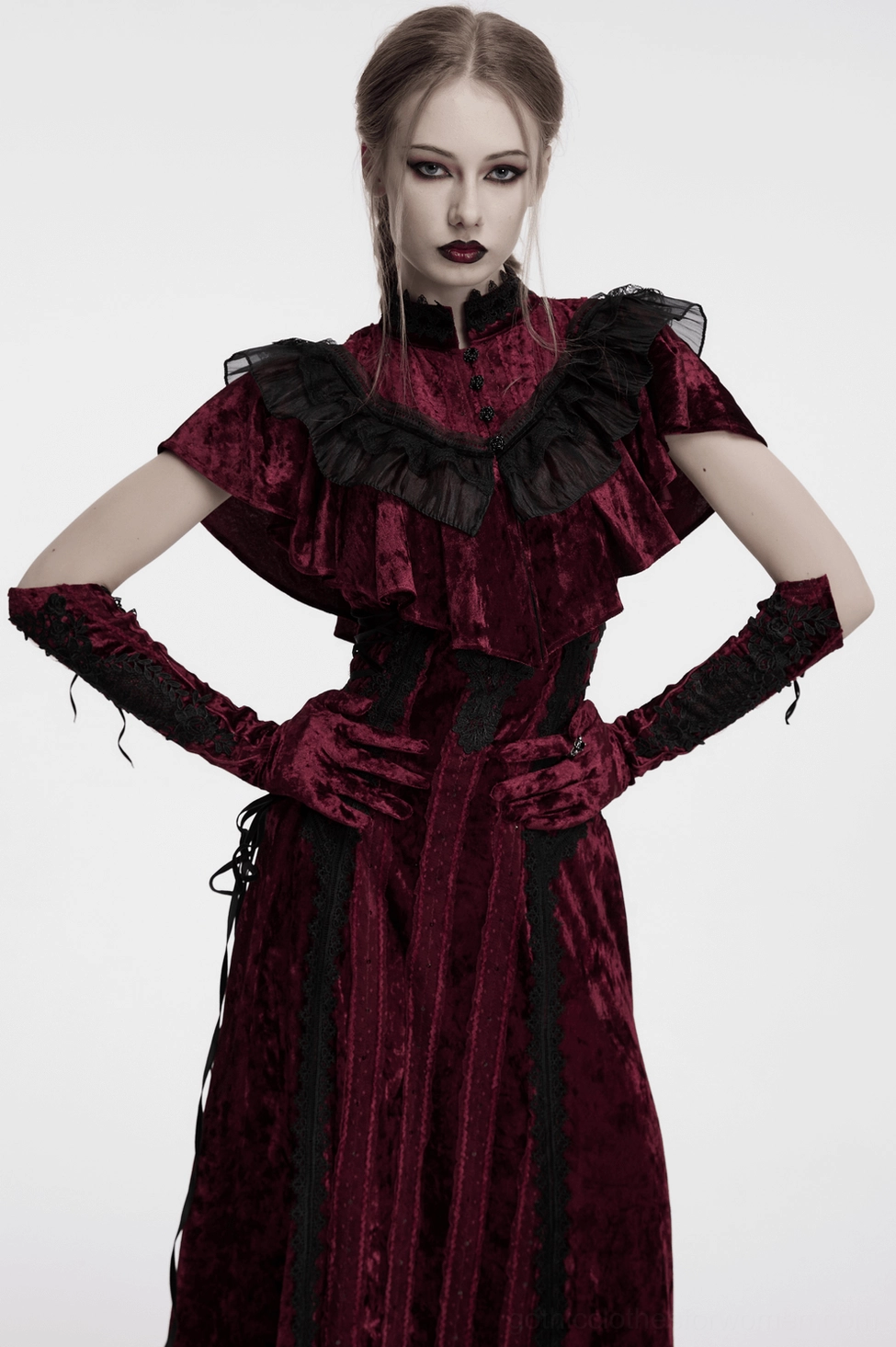 model in burgundy velvet opera gloves matching gothic dress with black lace accents, hands on hips pose