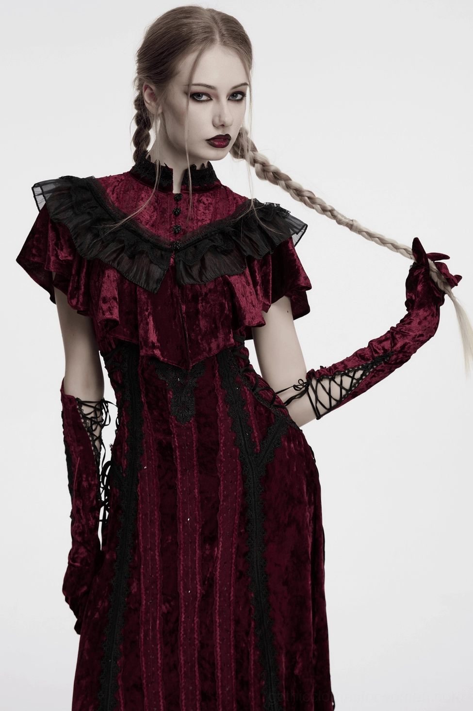 model wearing burgundy velvet opera gloves with matching gothic gown, hand posed in hair, side view