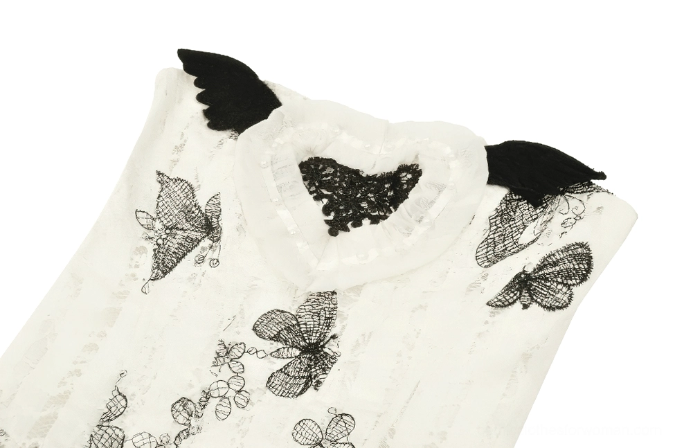 Close-up detail shot of gothic butterfly dress bust showing winged shoulder pads, heart-shaped lace decoration, and butterfly motifs