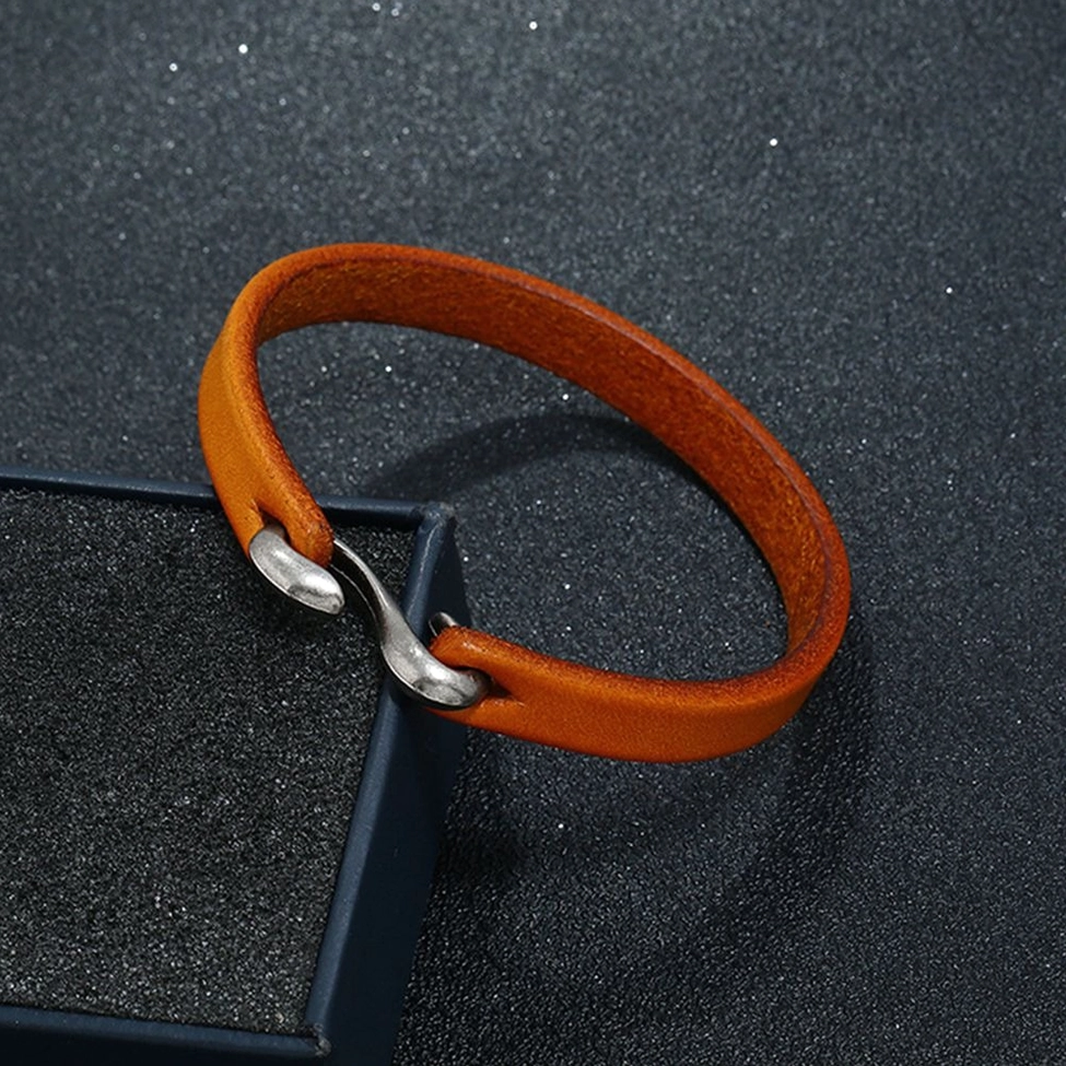 Camel tan leather cuff bangle displayed on dark textured background with black gift box - gothic jewelry unboxing