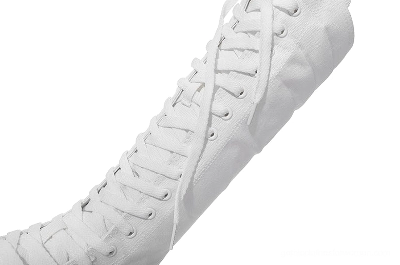 Close-up detail of white canvas boot shoelace structure and fabric texture
