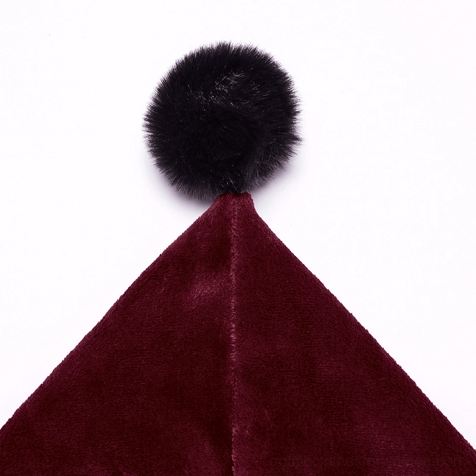 Close-up detail of black fluffy faux fur pompom adorning the hood of wine red velvet cape