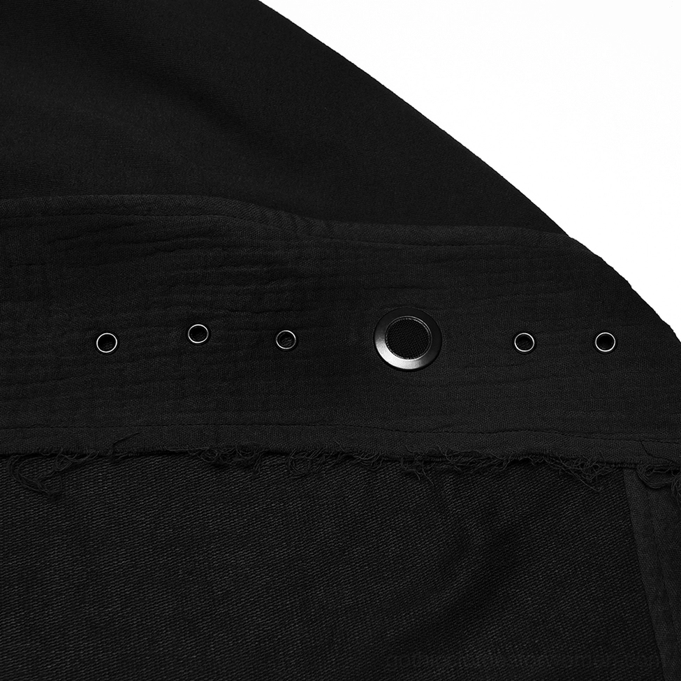 Close-up fabric detail of black post-apocalyptic cape vest, metal eyelets and frayed raw edge with matte distressed texture