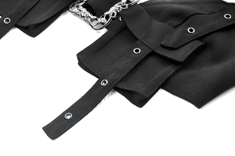 Macro close-up of black harness crop top's cargo pocket featuring metal eyelets, fabric construction, and adjustable strap details