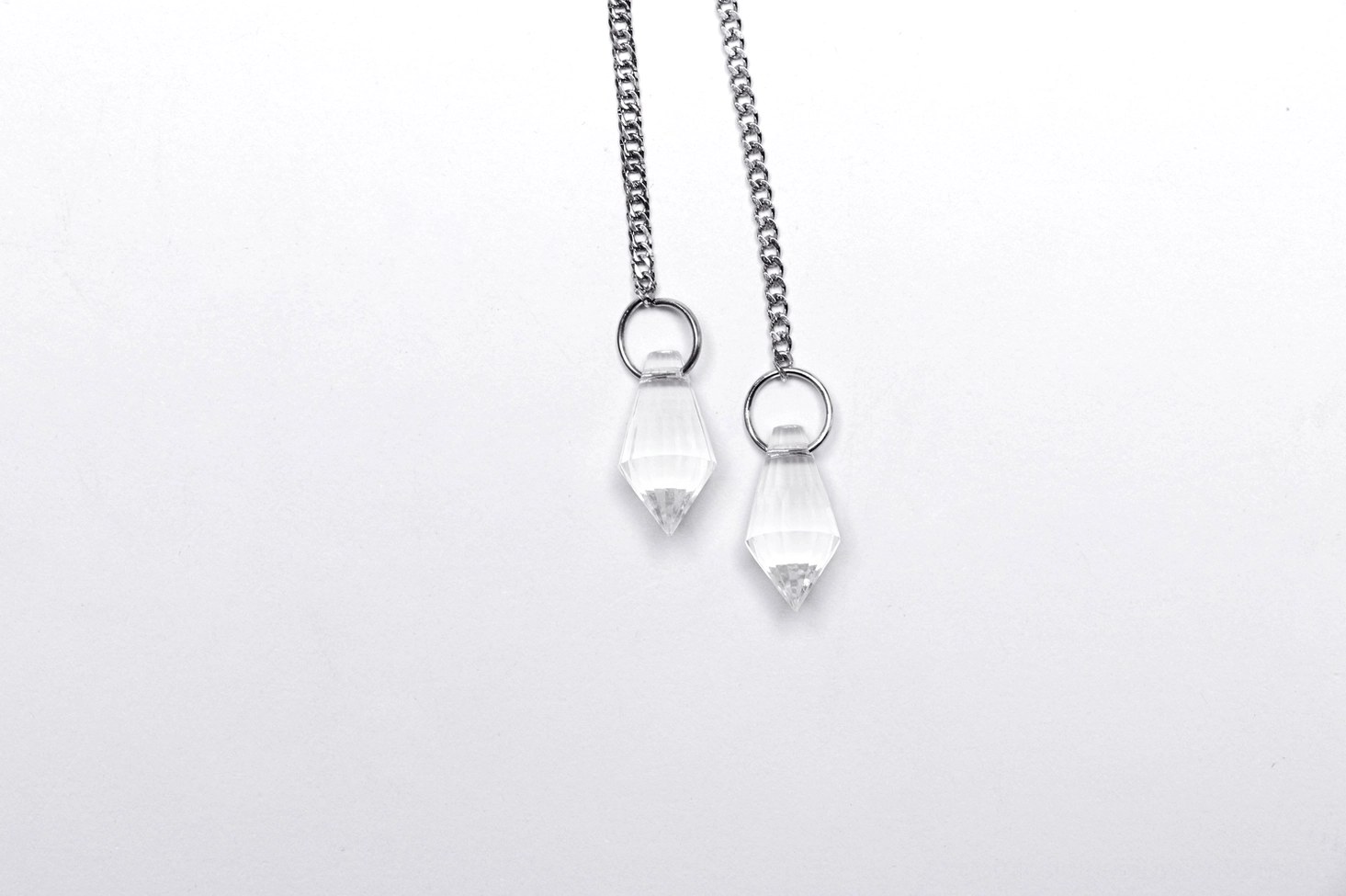 Celestial gothic crown dangling pendants close-up - faceted clear crystal drops silver chain straps and metal loop fasteners