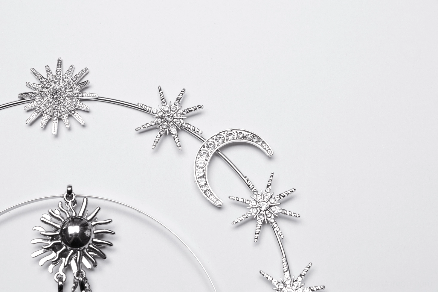 Celestial gothic crown partial view showing crescent moon star charms central sun motif and polished silver metal finish