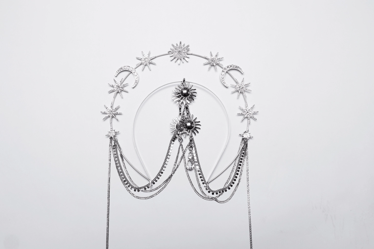 Flat lay side view of celestial gothic crown - silver hoop frame with star crescent moon embellishments and central sun motif