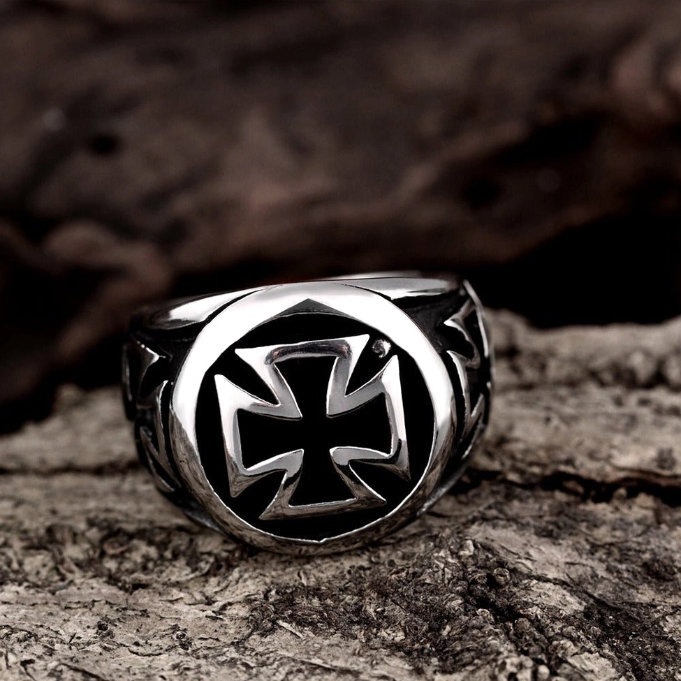 Celtic cross gothic ring top view on vintage weathered wood background showing silver-black metal finish