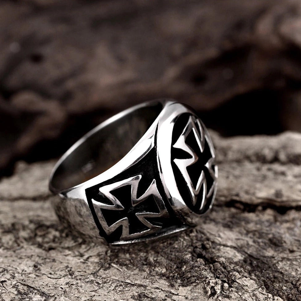 Gothic celtic cross signet ring side oblique angle on rustic tree bark showcasing embossed cross patterns