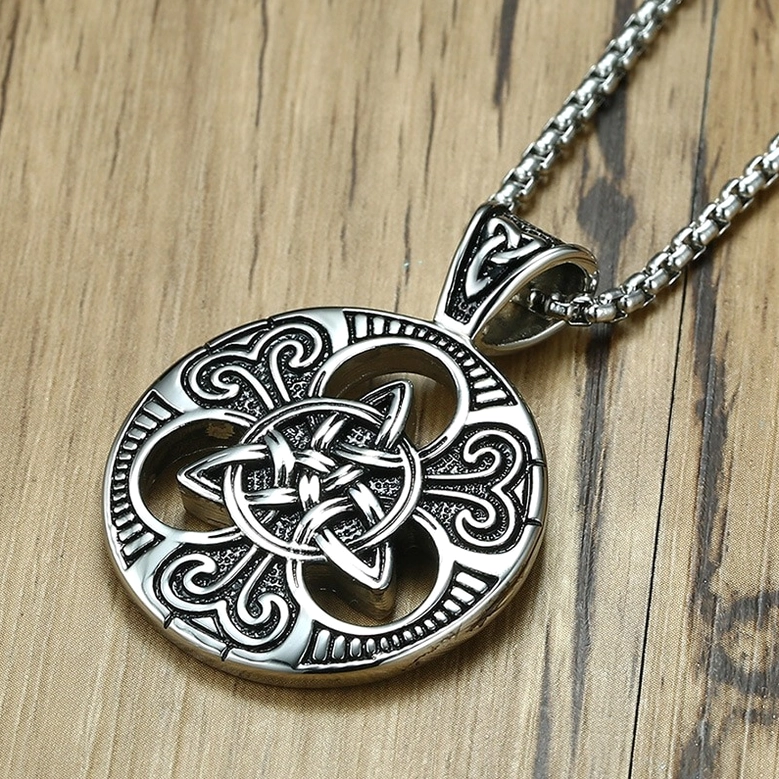 Stainless steel Celtic knot pendant with box chain, top angled view showing embossed scroll details and Celtic knot craftsmanship