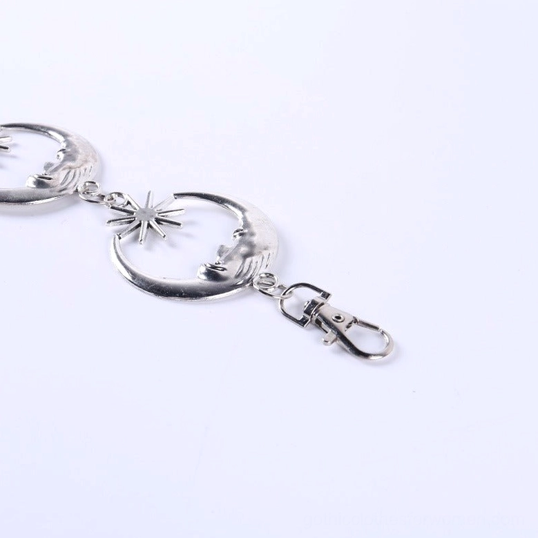 Close-up flat lay detail of silver metal buckle clasp and crescent moon link hardware