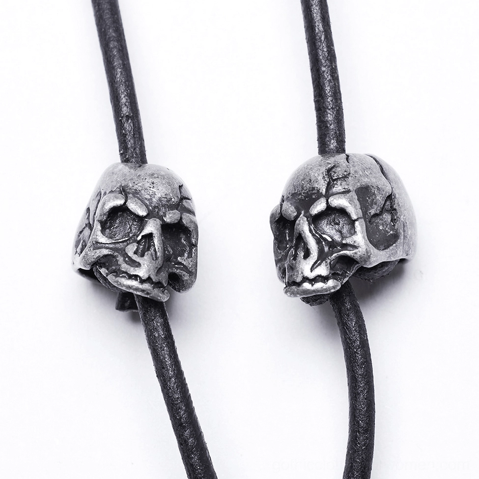 Silver skull metal beads and black leather cord close-up of chain body harness construction detail