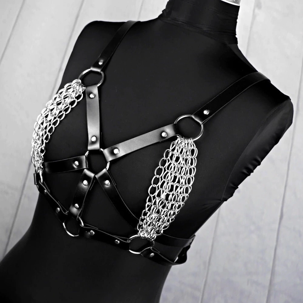 Gothic BDSM body harness on mannequin, front facing, featuring silver metal chain accents and adjustable leather straps