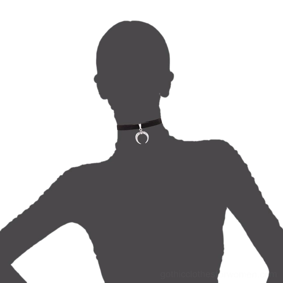 Silhouette demonstration of slim black velvet choker with crescent pendant on neck against dark background
