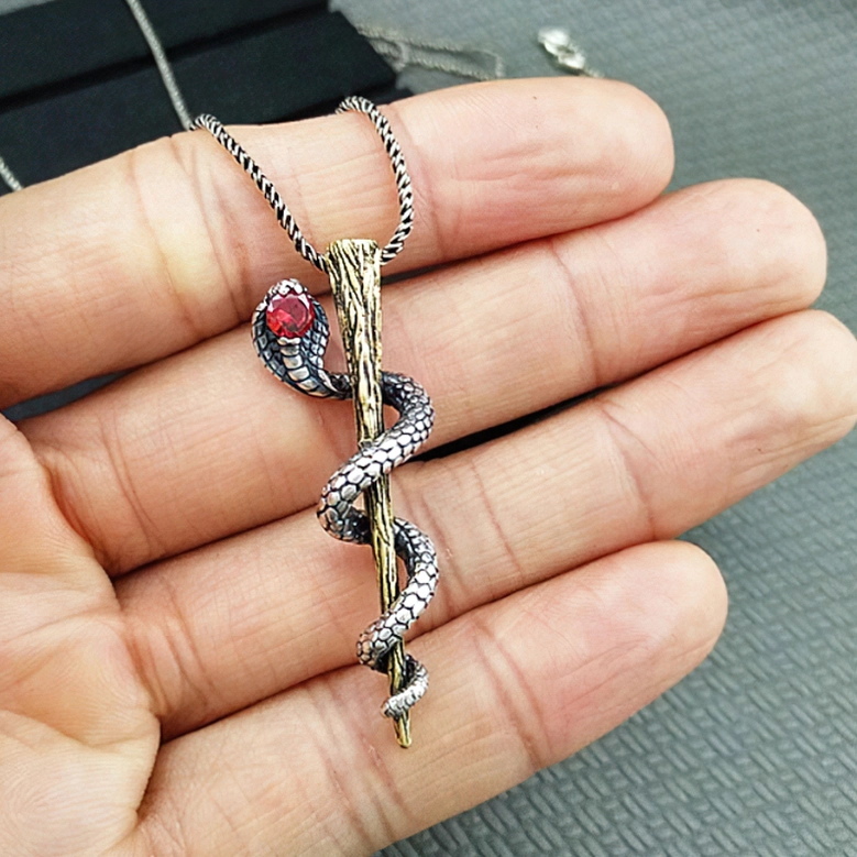 Cobra necklace pendant with red gemstone and twisted rope chain worn by model