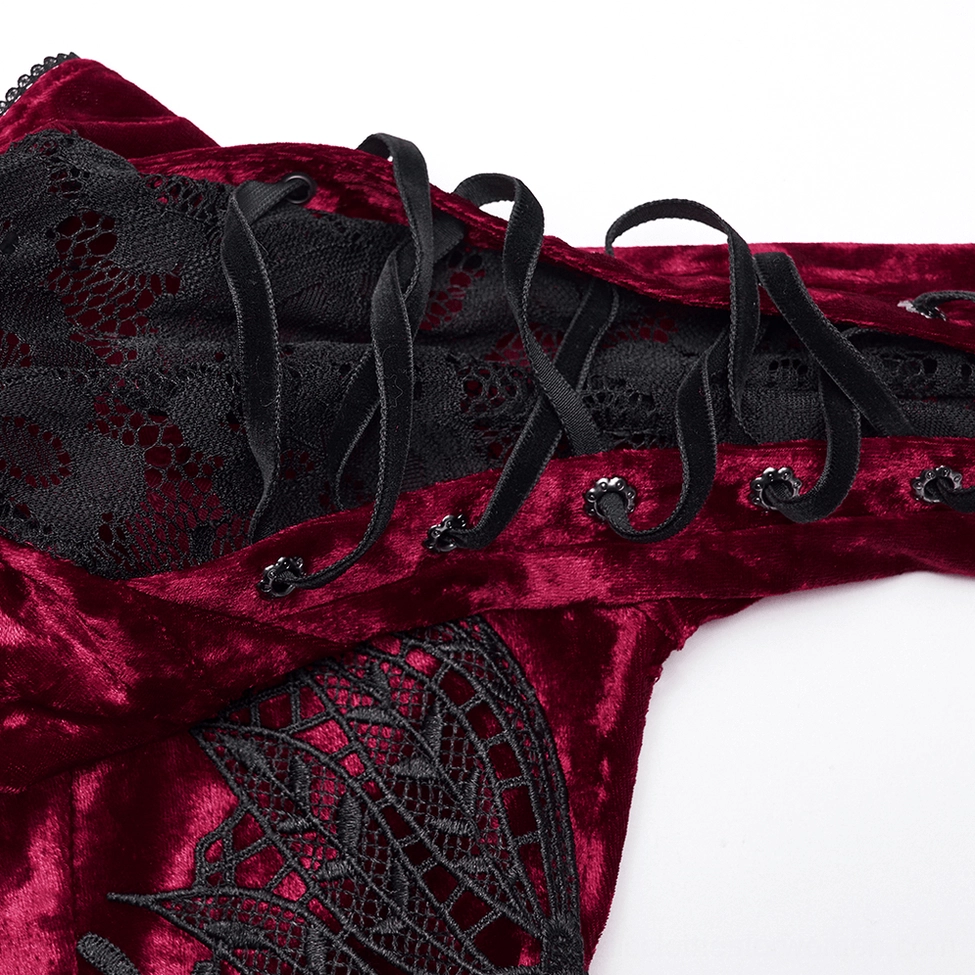 Close-up of lace-up corset back detail showing crushed velvet, black lace panels, metal eyelets, and ribbon laces