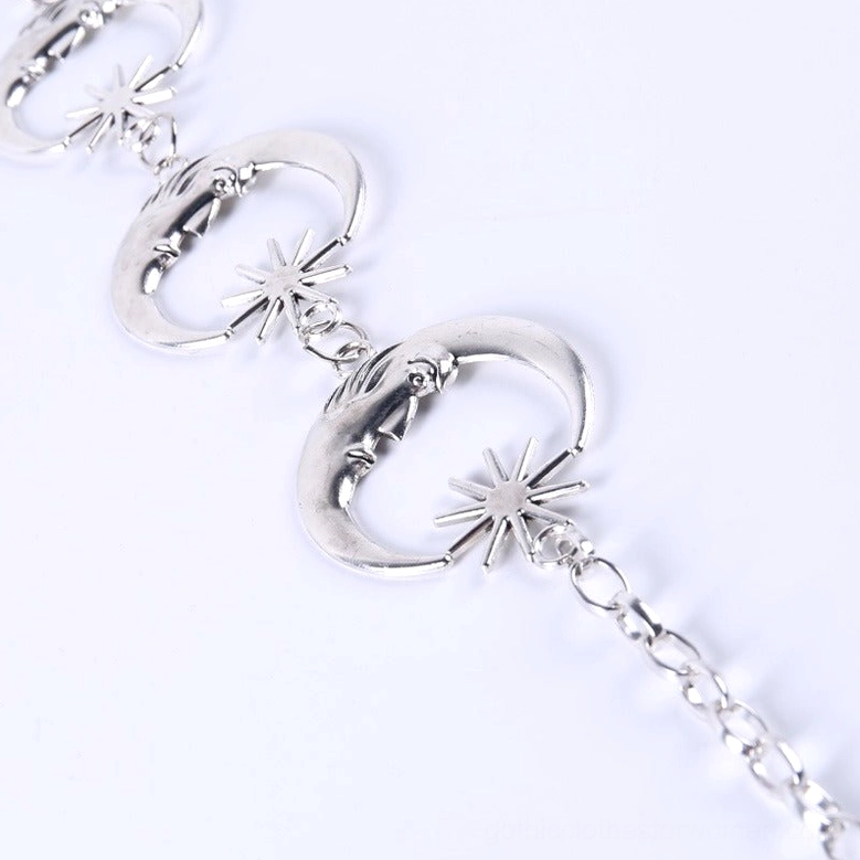 Partial view of silver chain waist belt showing crescent and star accent details in side flat lay perspective
