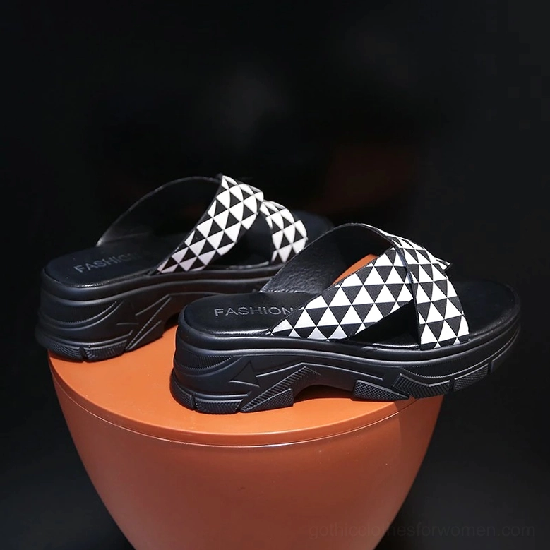 Gothic style platform sandal pair with black and white triangle pattern and thick chunky rubber sole, high angle side view