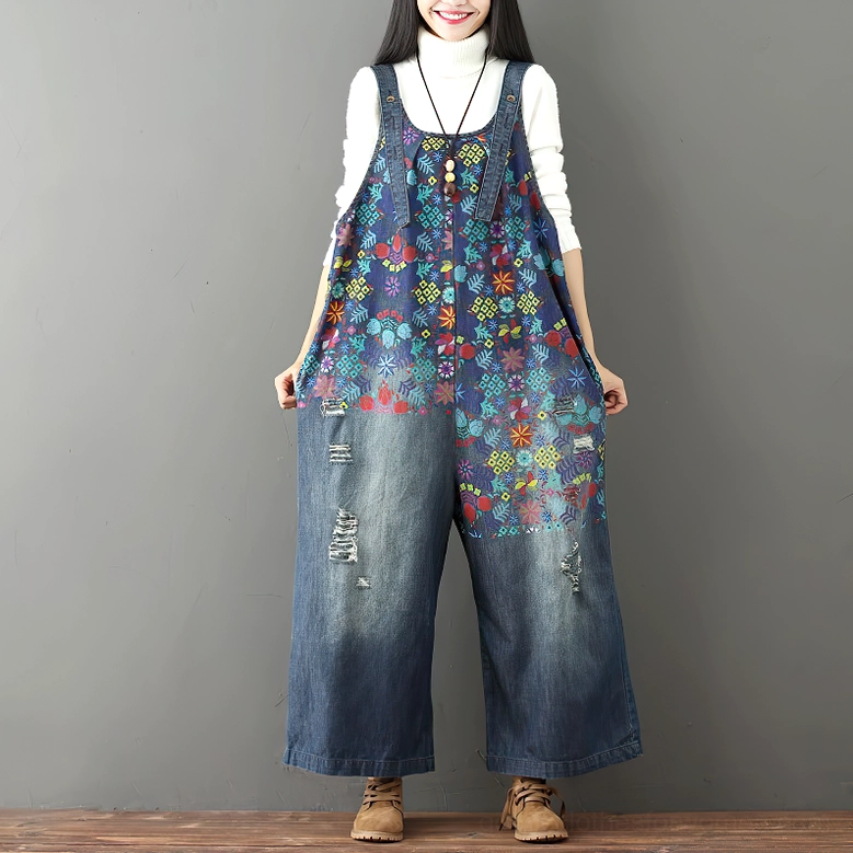 Front full-length view of dark wash floral denim wide-leg overalls with botanical print, simple casual styling on model