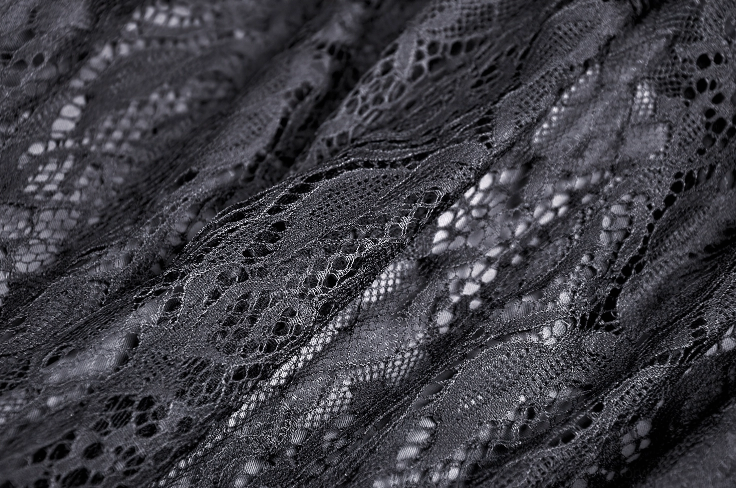 Close-up of delicate black floral lace weave showing sheer material and intricate pattern