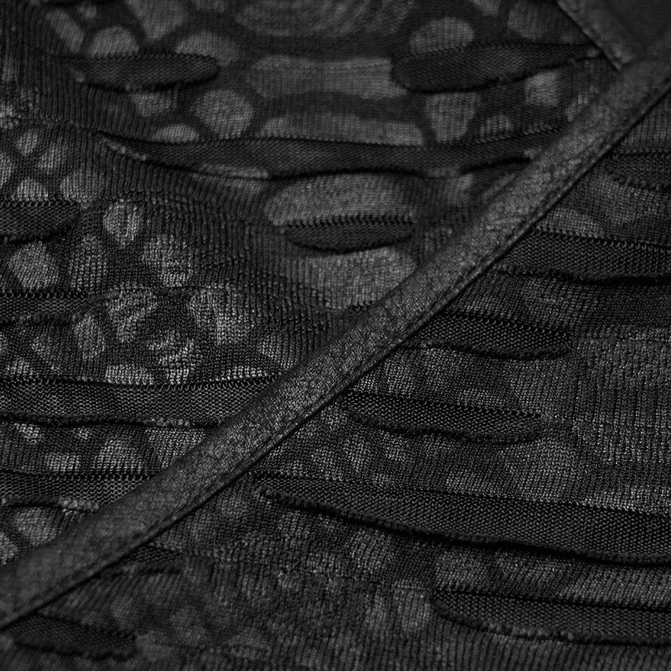 Extreme close-up of ripped slit mesh fabric showing leopard weave pattern and matte black finish texture