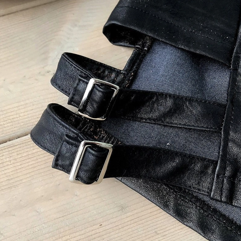 Dual adjustable buckle strap detail on black gothic shorts showcasing functional side cutout design