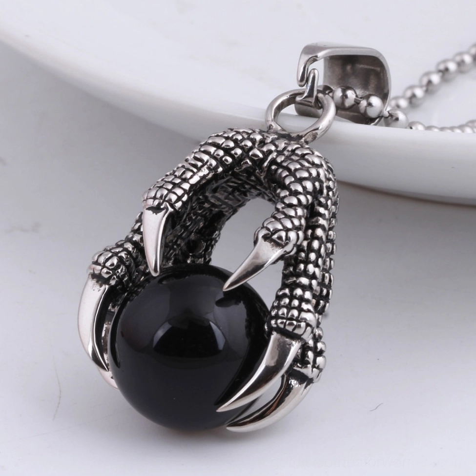 Close-up front view of black crystal dragon claw pendant with sharp retro silver tone claw tips