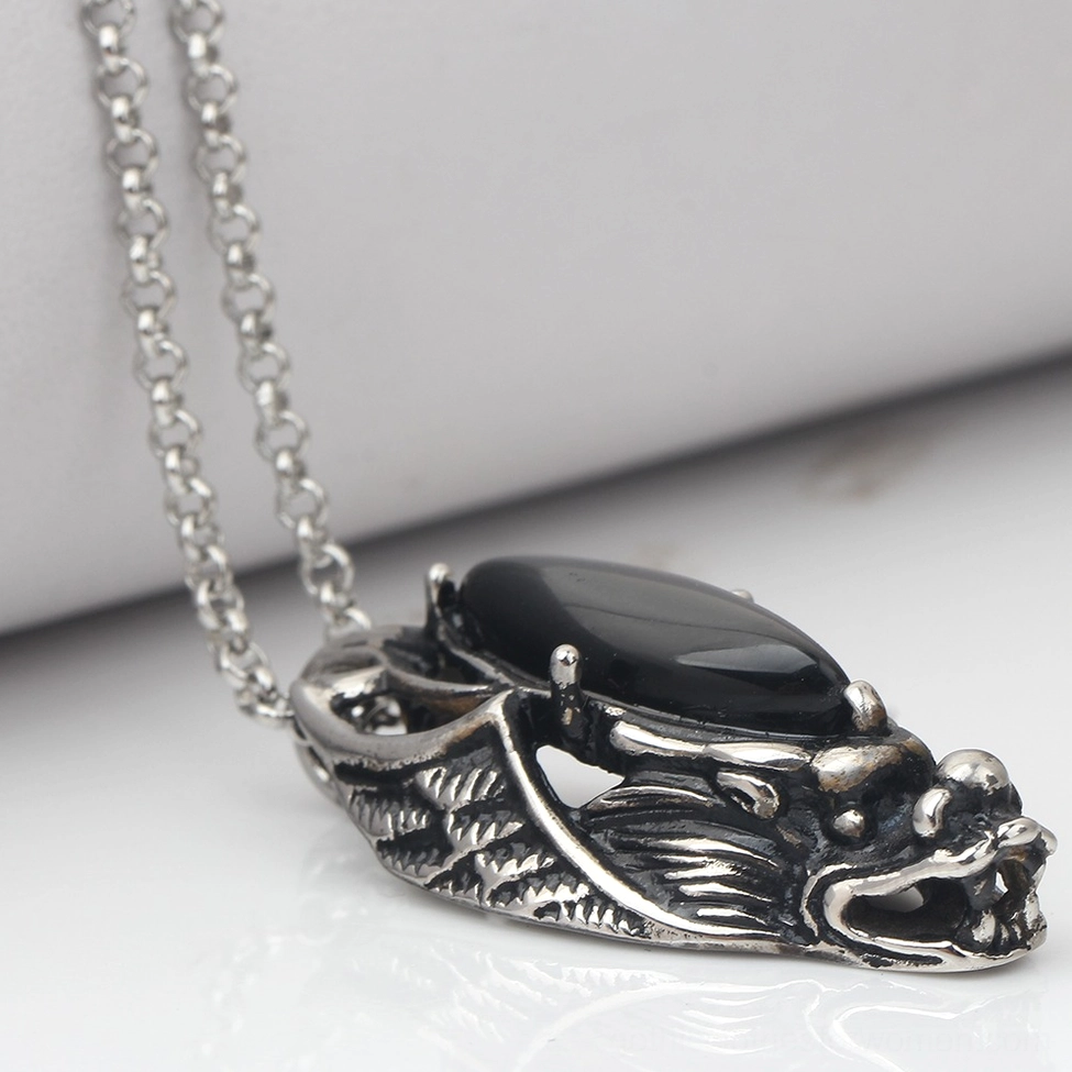 Dragon head stainless steel gothic pendant with detailed carving, side overhead view with studio lighting