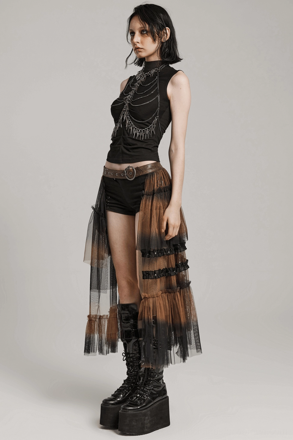 Dramatic black layered mesh half skirt with cracked leather belt, studio display showing full silhouette, architectural tulle construction and fitted waist design
