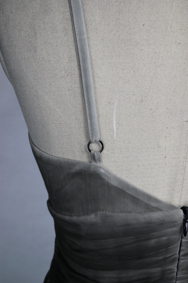 Close-up of dress shoulder strap D-ring detail and zipper closure on chiffon fabric