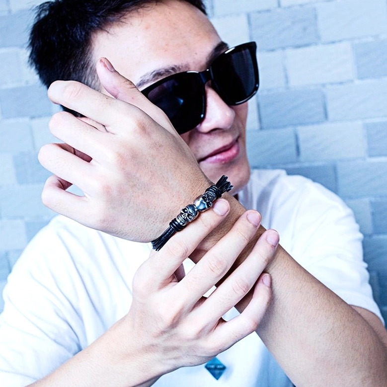 Double skull gothic bracelet worn on both wrists close-up dual wrist styling on mosaic background