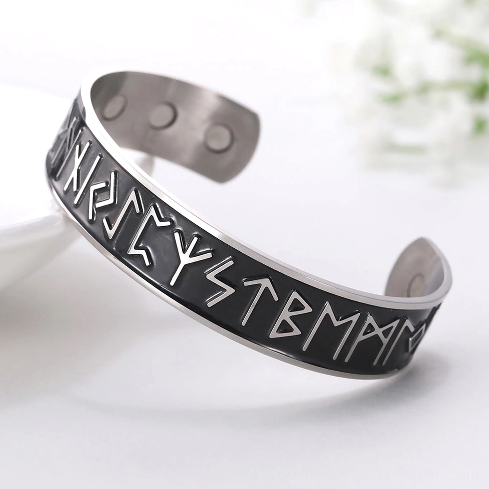 Polished stainless steel nordic rune bracelet with black enamel runic engravings floral background