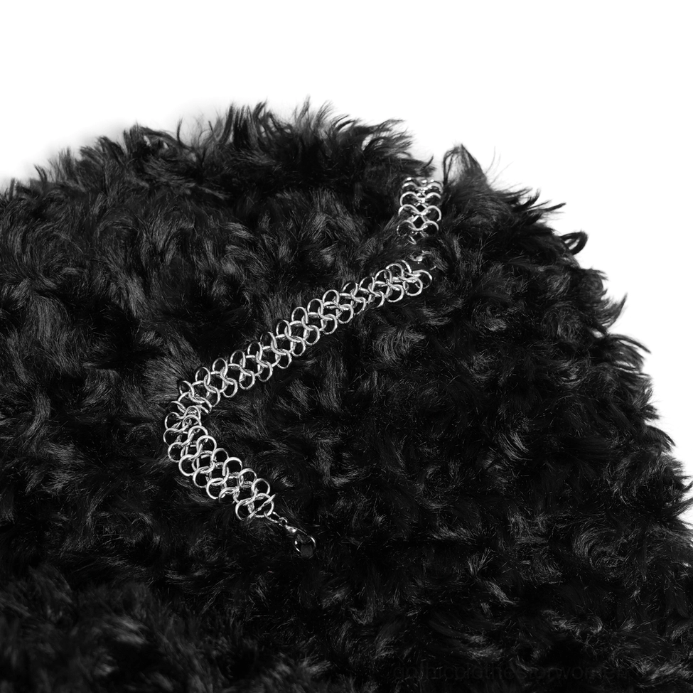 Black faux fur cape close-up showing curly texture and silver chain clasp