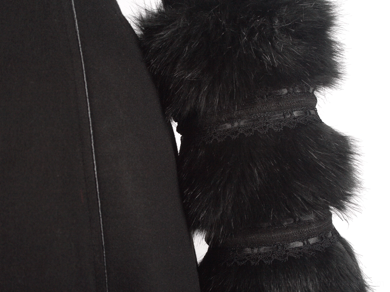 Close-up of coat cuff seam and layered faux fur trim with lace band accents