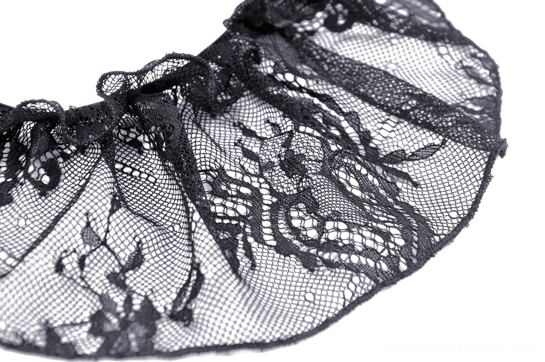 Curved view of cutout floral lace pattern and ruffled edge trim on gothic dress hem