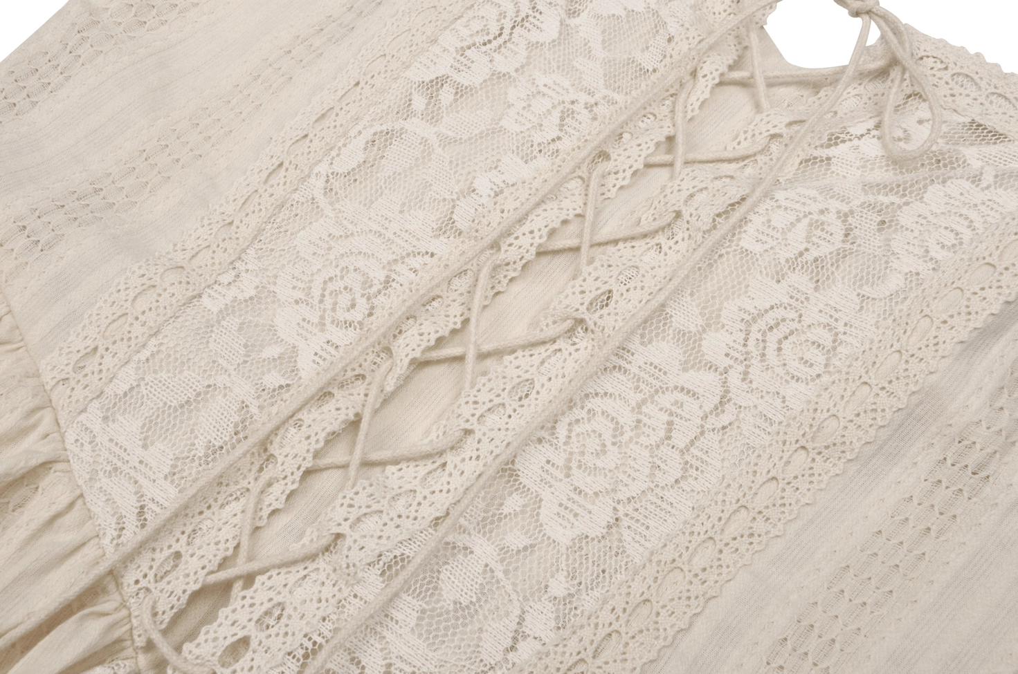 Floral lace fabric close-up showing intricate botanical pattern and lace-up strap details of the gothic dress
