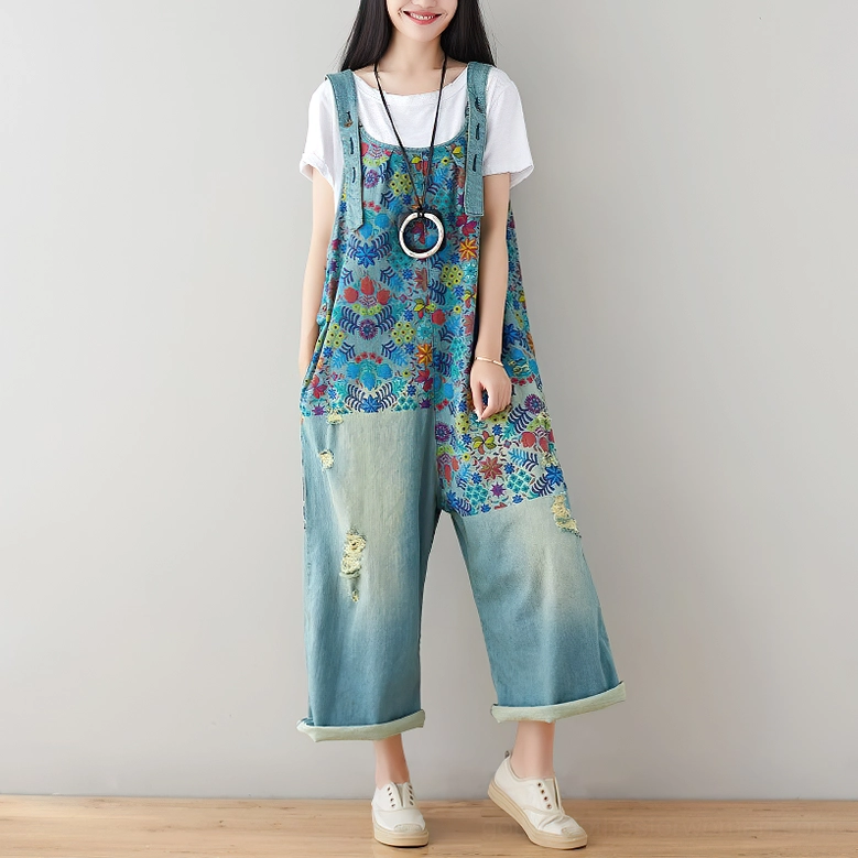 Floral denim overalls front full view with rolled pant cuffs and decorative pendant necklace accessory, demonstrating layered styling options