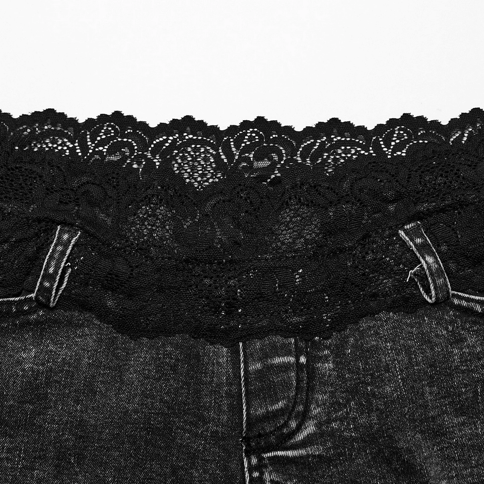 Flat lay close-up of black lace waist trim with floral scalloped pattern, belt loops, and acid-washed denim texture