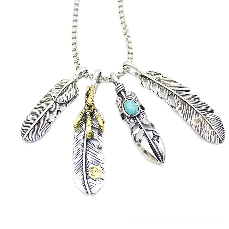 Four feather pendant necklace flat lay - multi-feather gothic design with silver gold turquoise stone details
